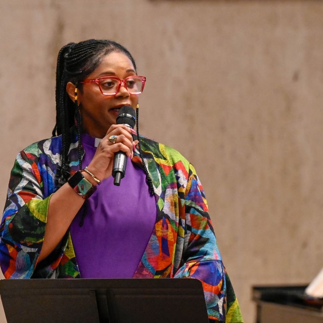Young woman speaking at a pulpit.